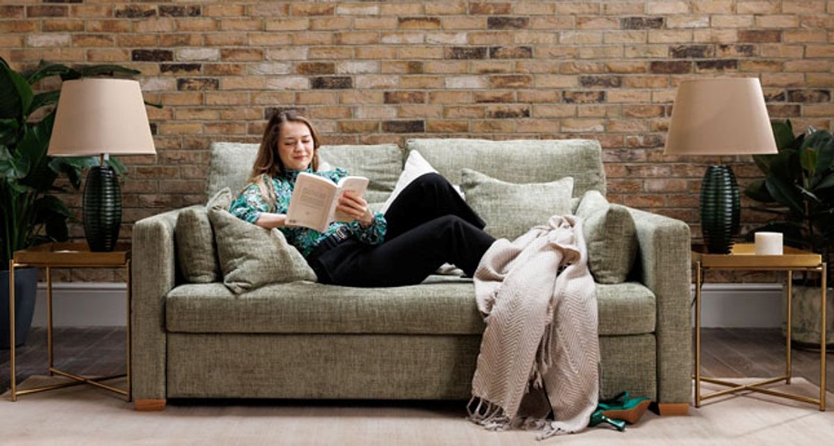 cambio sofa bed with woman sitting while reading a book